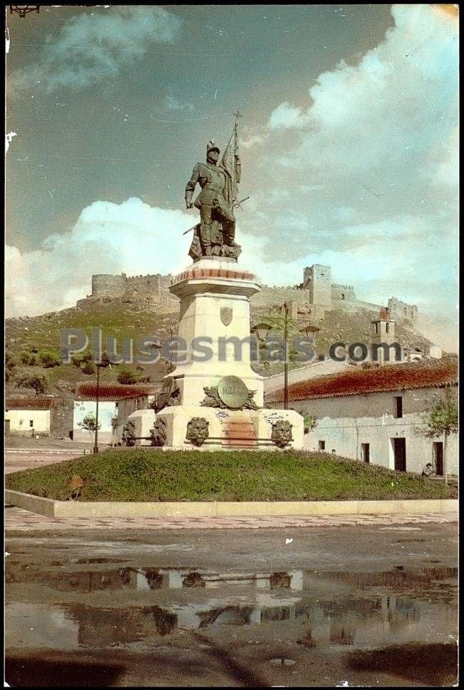 Monumento a hernán cortés y al fondo el castillo de medellín (badajoz)